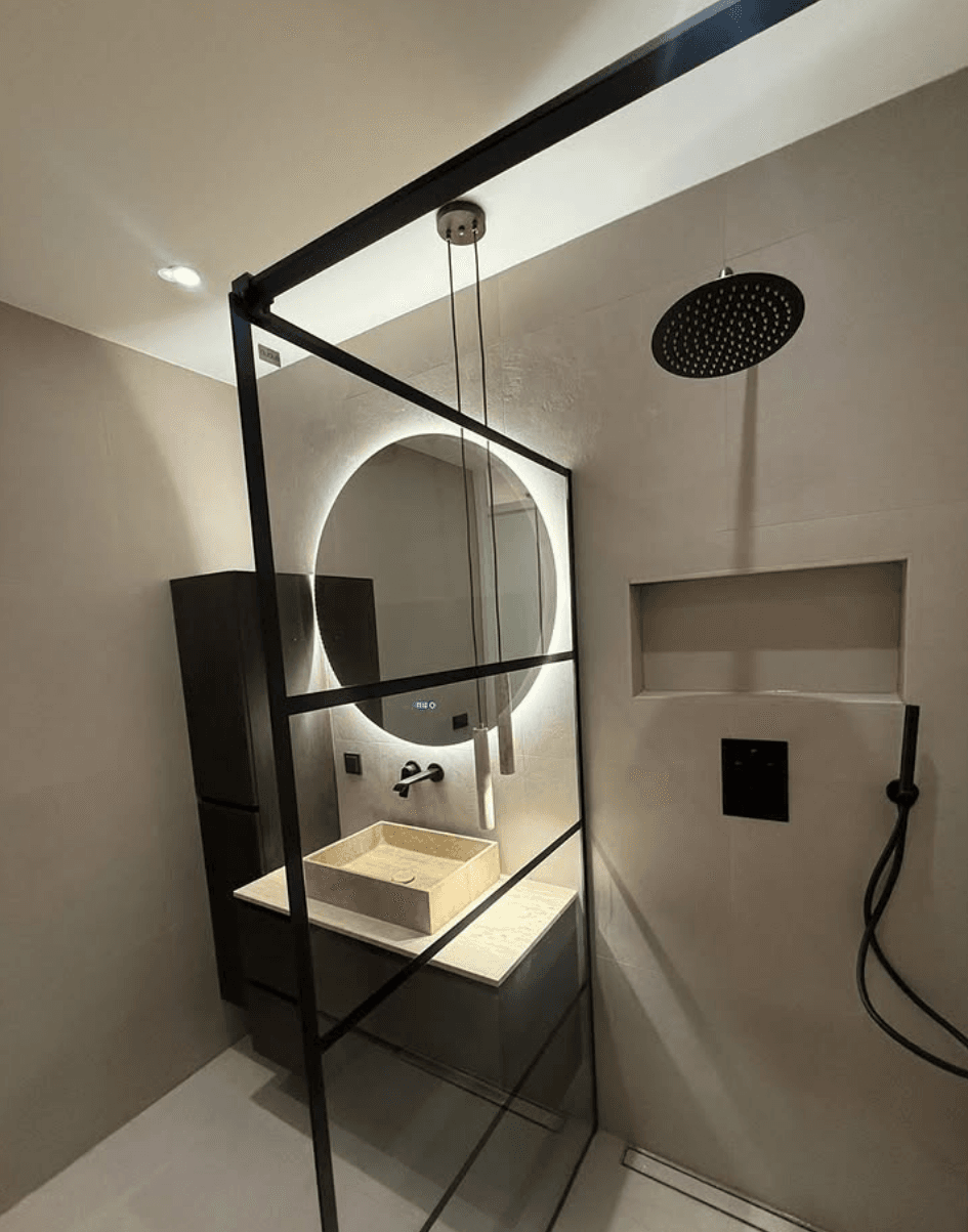 Afgewerkte badkamer met modern wastafelmeubel en zwarte accenten.