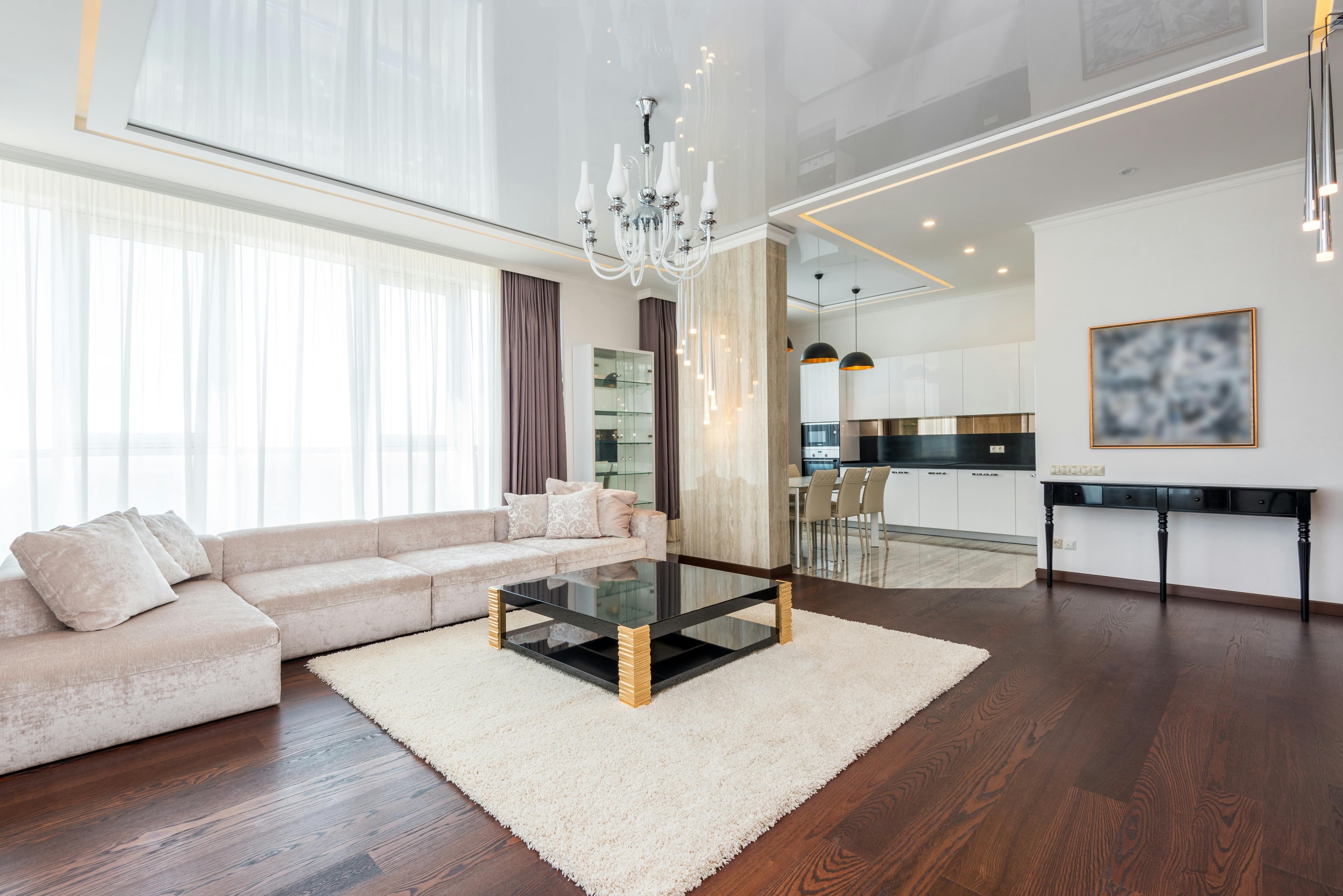 Luxe woonkamer met hoge plafonds en rustige materialen.