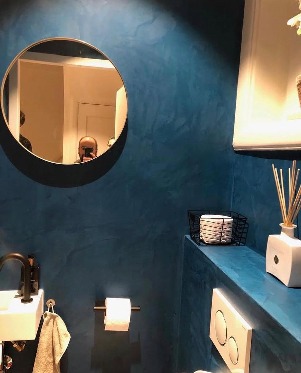 Afgewerkte toiletruimte met donkere wandafwerking en strakke details.