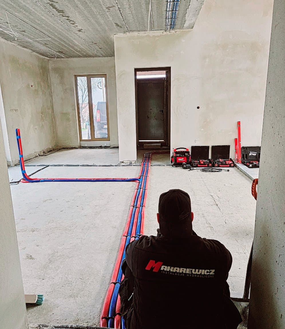Instalator podczas prowadzenia instalacji wodnej i grzewczej w domu.